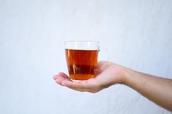 glass cup of darjeeling tea in hand